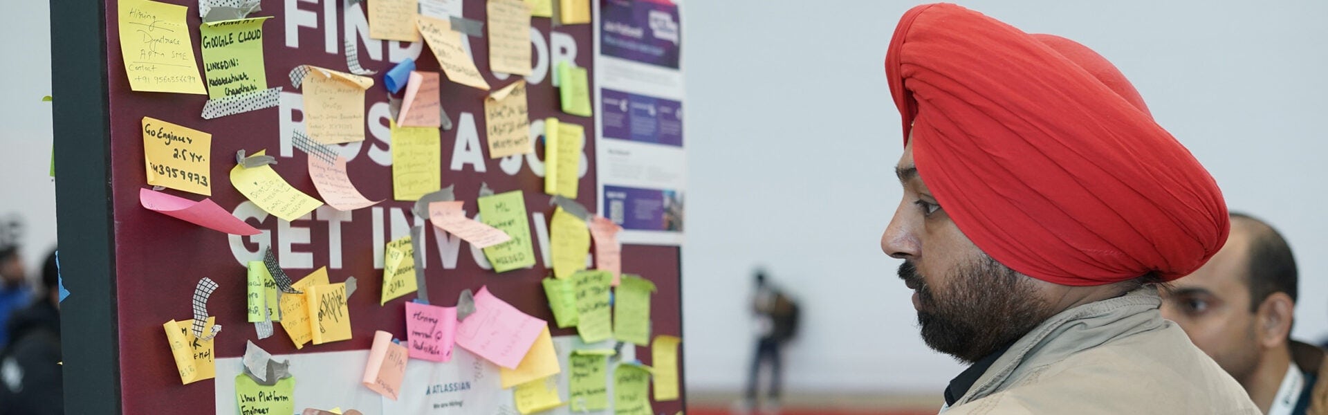 A man standing in front of a board covered with sticky notes.